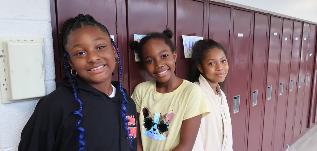 three students in front of lockers